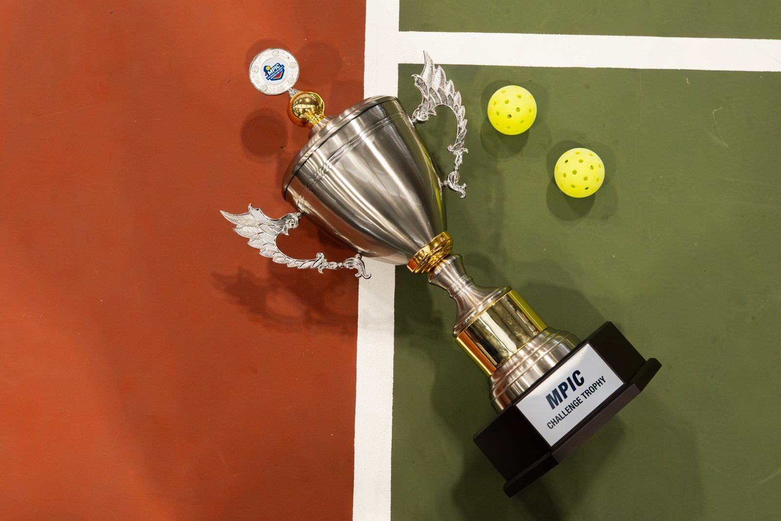 The MPIC Challenge Trophy on court with pickleballs